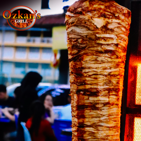 A large vertical spit of roasting doner kebab meat spinning at the Ozkan's Grill in Berwick.
